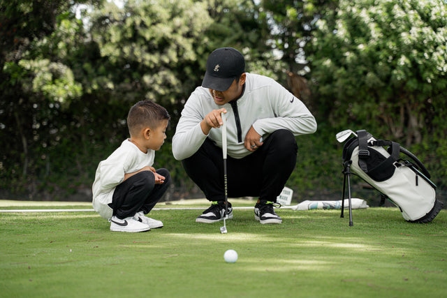 Dad teaching son golf